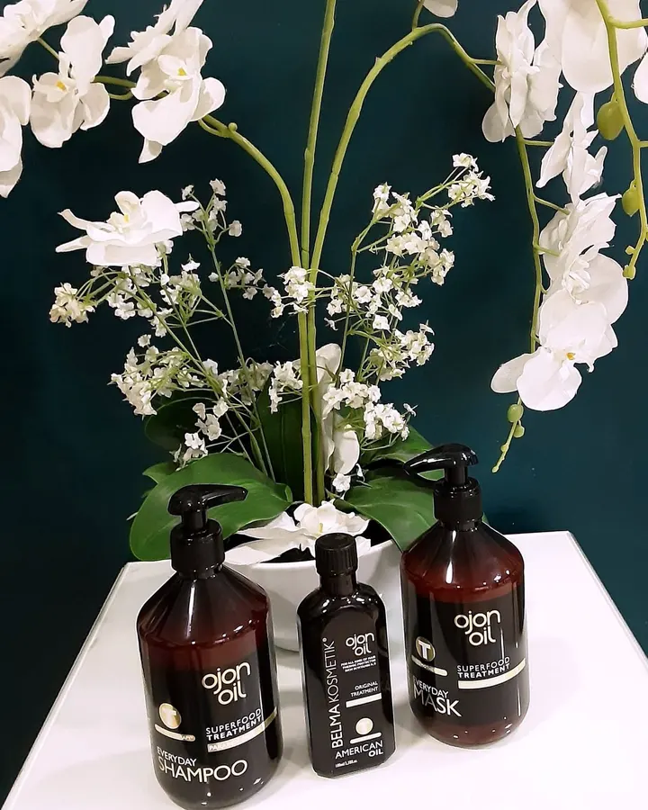 Soins BelmaKosmetik et orchidées blanches, devant le mur bleu pétrole