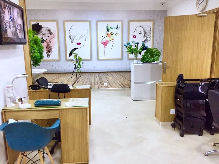 L’accueil : bureau en chêne clair et quatre aquarelles de mode encadrées